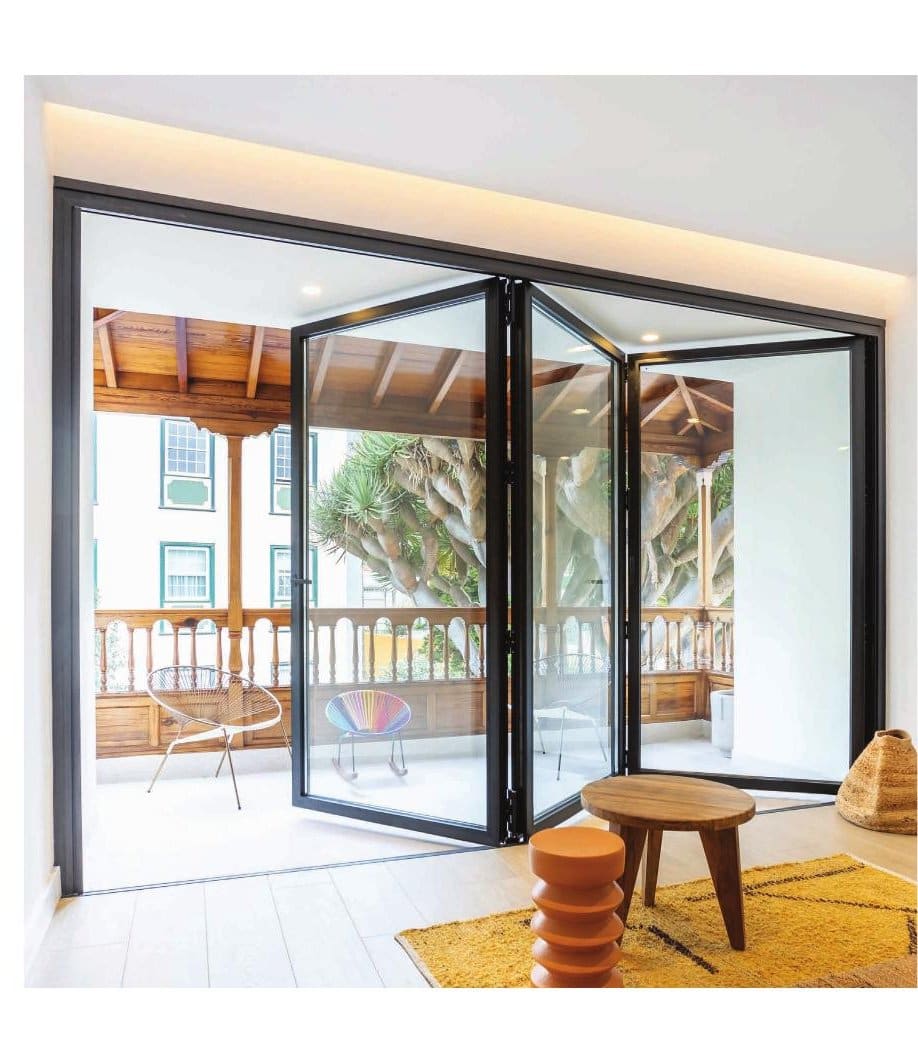 Three-leaf anthracite aluminium bifold doors open onto a garden terrace
