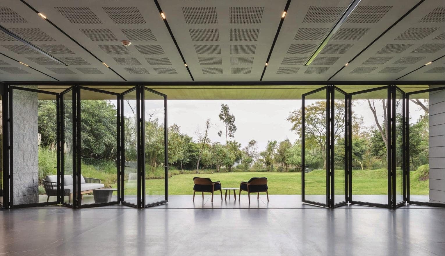 Wide aluminium bifold doors opening across a contemporary garden elevation