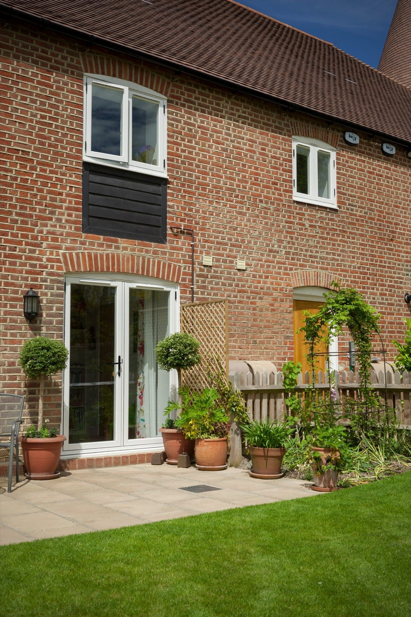 Oak-effect composite door on a brick courtyard entrance