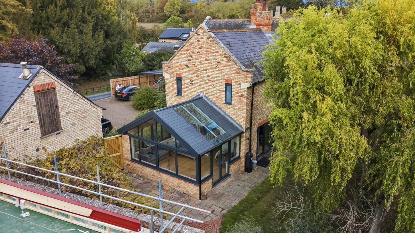 Aerial view of a canalside cottage with new conservatory featuring anthracite frames and twin skylights