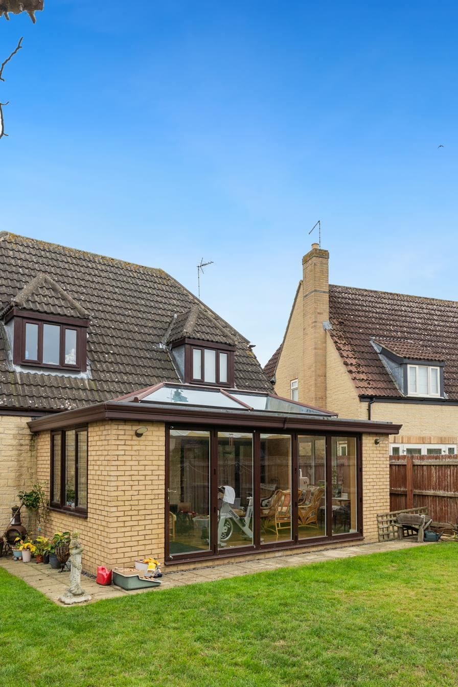 Side view of a conservatory with roof lantern on a stone bungalow