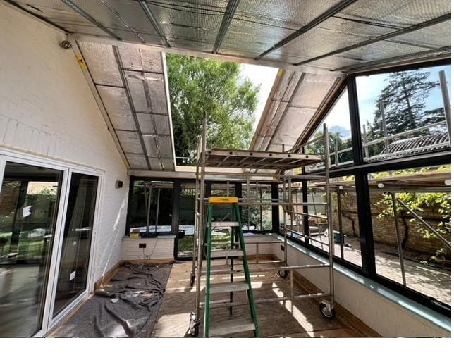 Conservatory interior during installation with scaffolding and insulation in place