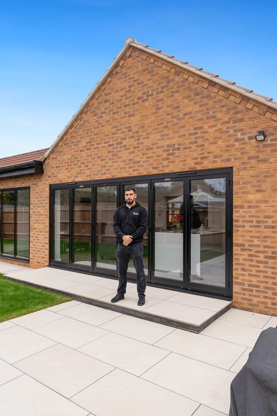 Tariq Quaddus in front of a completed bifold door installation