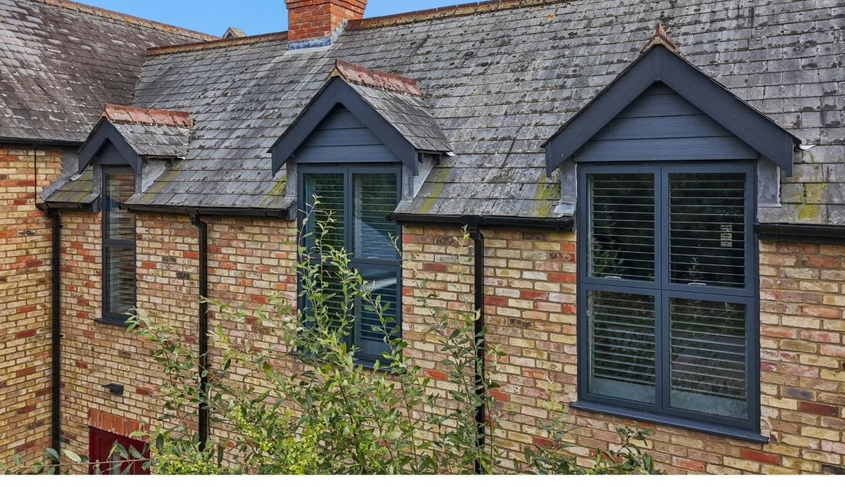 Anthracite UPVC dormer windows on a yellow-brick cottage with slate roof
