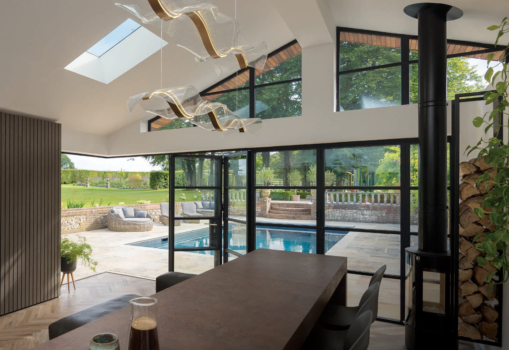 Origin aluminium windows and bifold doors across the rear of a garden room overlooking a pool